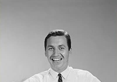 A black and white photo of a man, guide for fathers, holding two babies.
