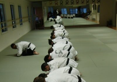 A group of Martial Artists kneeling down in a karate room.