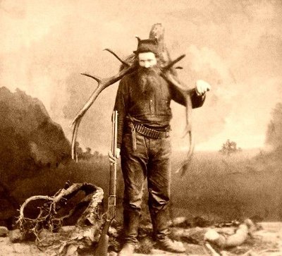 Northwest vintage mountain man carrying antlers.