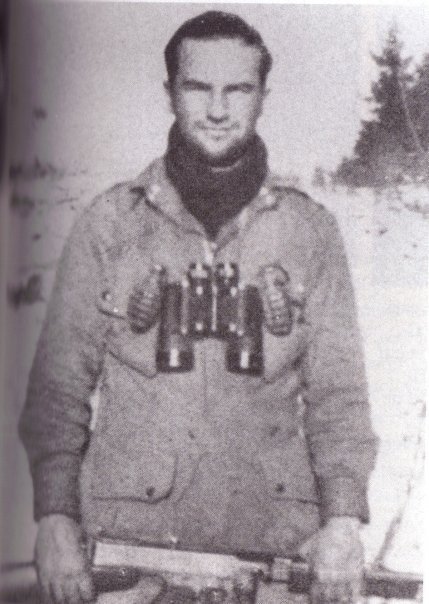Ron Speirs, a man from Easy Company, standing in the snow with a rifle.