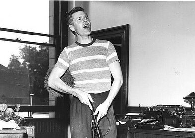 A man cleaning a room with a vacuum.