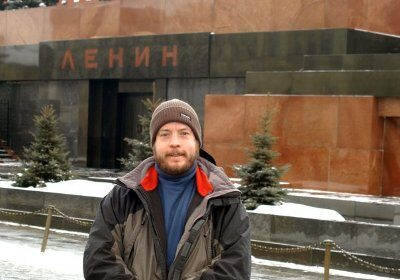 A video game producer standing in front of a building in the snow.