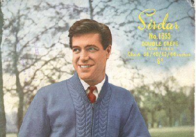 A man in a blue sweater is posing for a photo while following the Man's Guide to stylish sweaters.