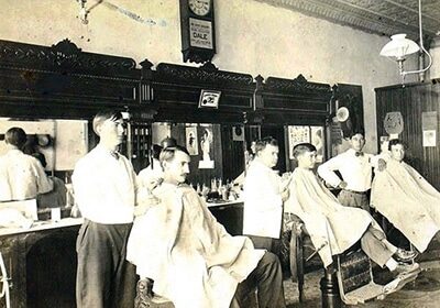 An intriguing old photo captured inside a barbershop, exuding a nostalgic atmosphere with the faint lingering smell of scented hair products and aftershave.
