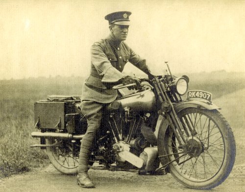 A military soldier wearing uniform riding on motorcycle. 