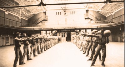 A photo depicting men in uniform showcasing their athleticism and strength within a spacious room, creating an atmosphere of increased energy.