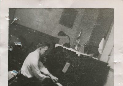 A photo capturing the deliberate practice of a great man playing a piano.