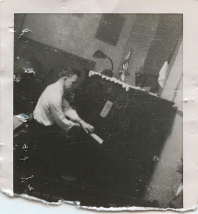 A photo capturing the deliberate practice of a great man playing a piano.