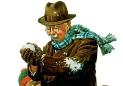 A perfect picture of a man with a shovel making a snowball in the snow.