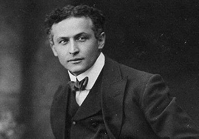 A Harry Houdini-esque man in a suit striking a pose for a photo, radiating manliness.