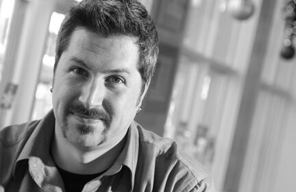 A black and white photo of an advertising executive with a mustache.