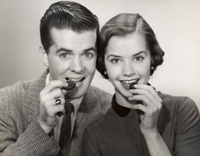 Couple smiling while eating cookies.