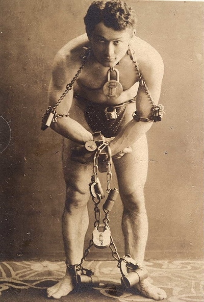 Harry Houdini tied up with chain locks. 