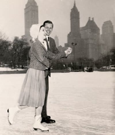 Couple enjoying ice skating in city. 