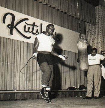 Boxer doing rope-jumps in front of trainer.