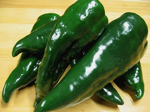 Poblano green peppers on cutting board.