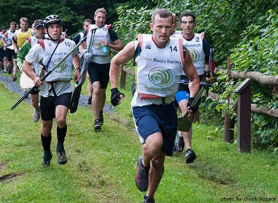 Man running with canoe paddles on the ground.