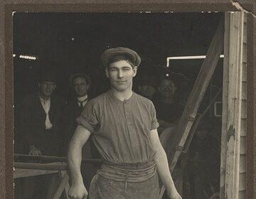 An old photo of a man holding a hammer, showcasing the importance of where you live for setting up shop.