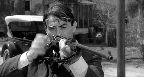 Gregory Peck holding a gun.