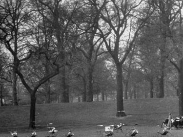 A man is unleashing his power during a relaxing nap in the park, surrounded by chairs.