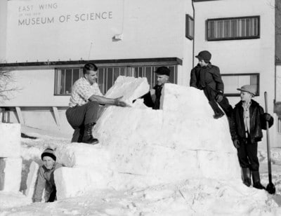 Vintage group of men making snow fort. 