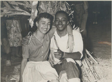 A man and a woman posing in front of a hay bale, showcasing one of the unorthodox places to meet and potentially connect with women.