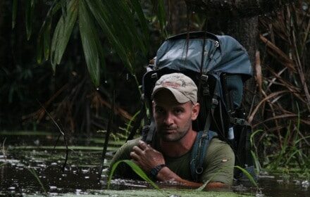 A modern day adventurer with a backpack in a swamp.