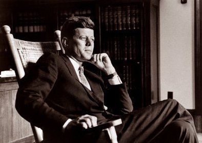 John Kennedy sit on a large rocking chair. 