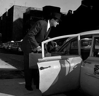 Vintage man sitting in the taxi with briefcase.