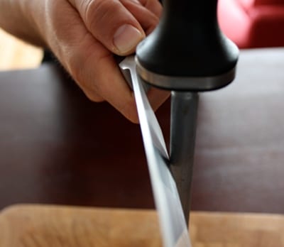 Kitchen knife sharpening with steel rod. 