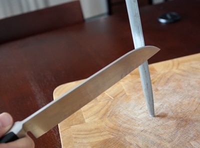 Kitchen knife sharpening with steel rod.