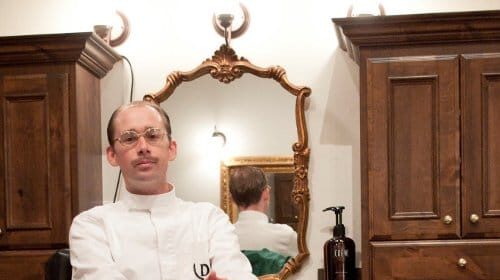 A barber working on a customer in a barber shop.
