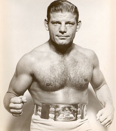 Wrestler posing with belt. 