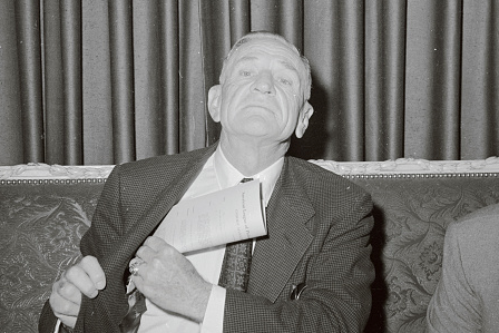 A man in a suit relaxing on a couch.