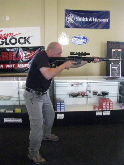 Man shooting a rifle in gun shop. 