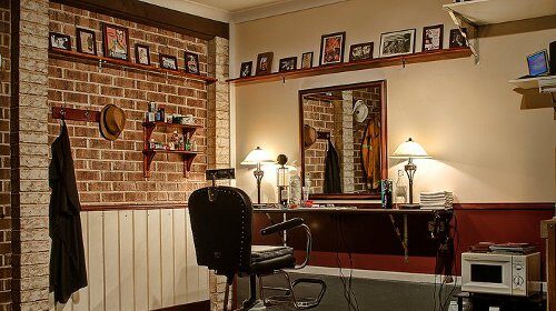 A garage transformed into a barbershop, complete with a barber chair and a mirror.