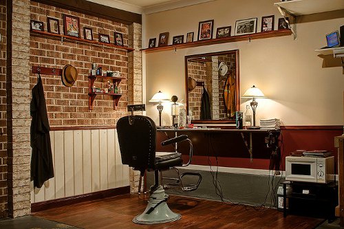 A garage transformed into a barbershop, complete with a barber chair and a mirror.