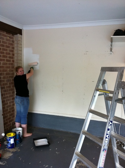 Turning garage into barbershop and man painting the walls.