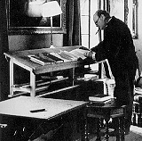 Winston Churchill working and writing at standing desk.