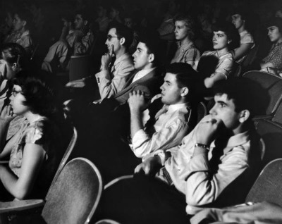 Patrocinadores de cinema vintage sentados na cadeira.