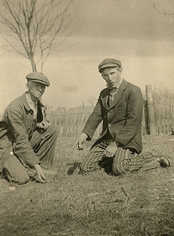 Vintage men playing mumblety-peg pocket knife game.