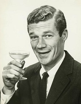Vintage man holding up cocktail glass.