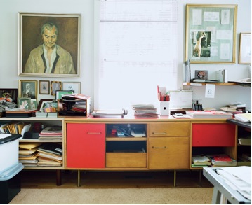 Mid century modern vintage desk with red doors in the office.