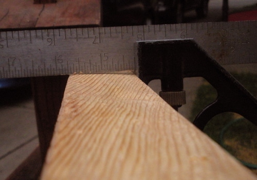 Measuring the wood with ruler.