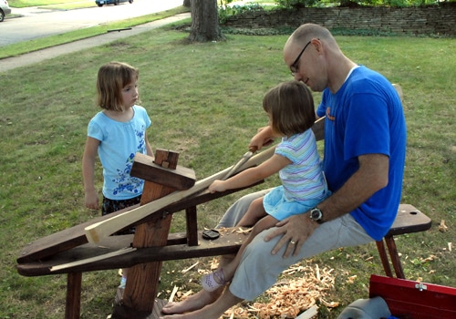 Kids helping in making of canoe paddle.