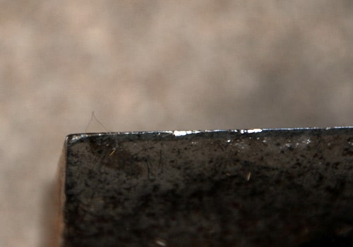 Edge of wood splitter maul ax looking dull before sharpening.