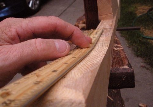 Making canoe paddle and marking measuring blade close up.