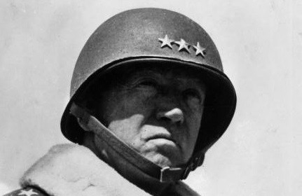 A black and white photo of a man in a military uniform, possibly General George S. Patton.