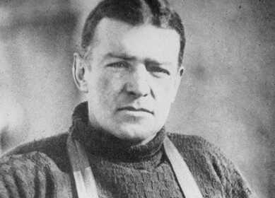A vintage photograph of Ernest Shackleton, a natural-born leader and pioneer, dressed in a cozy sweater and timeless suspenders.