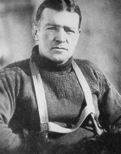 A vintage photograph of Ernest Shackleton, a natural-born leader and pioneer, dressed in a cozy sweater and timeless suspenders.